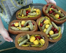 Gilded pickles on bread boats